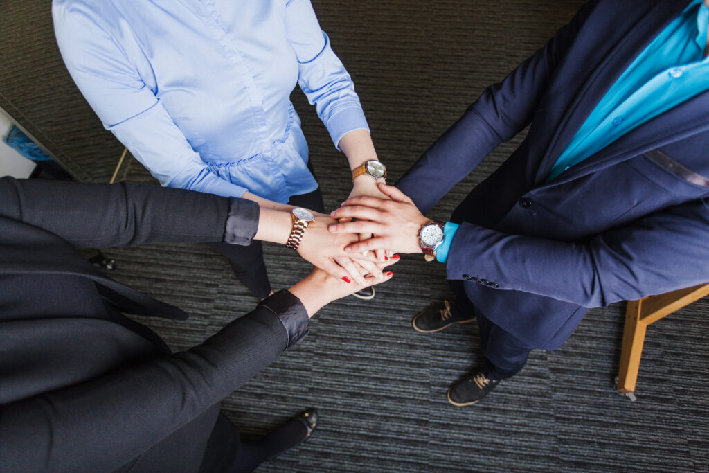 people standing office holding hands together