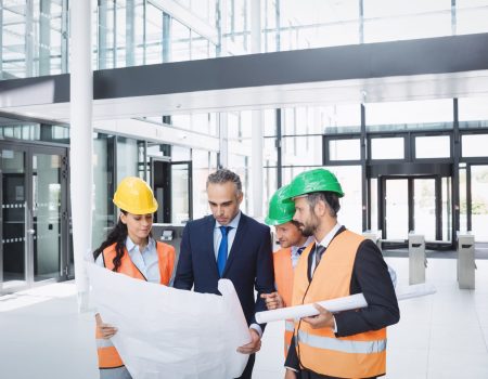 businessman discussing on blueprint with architects in office building